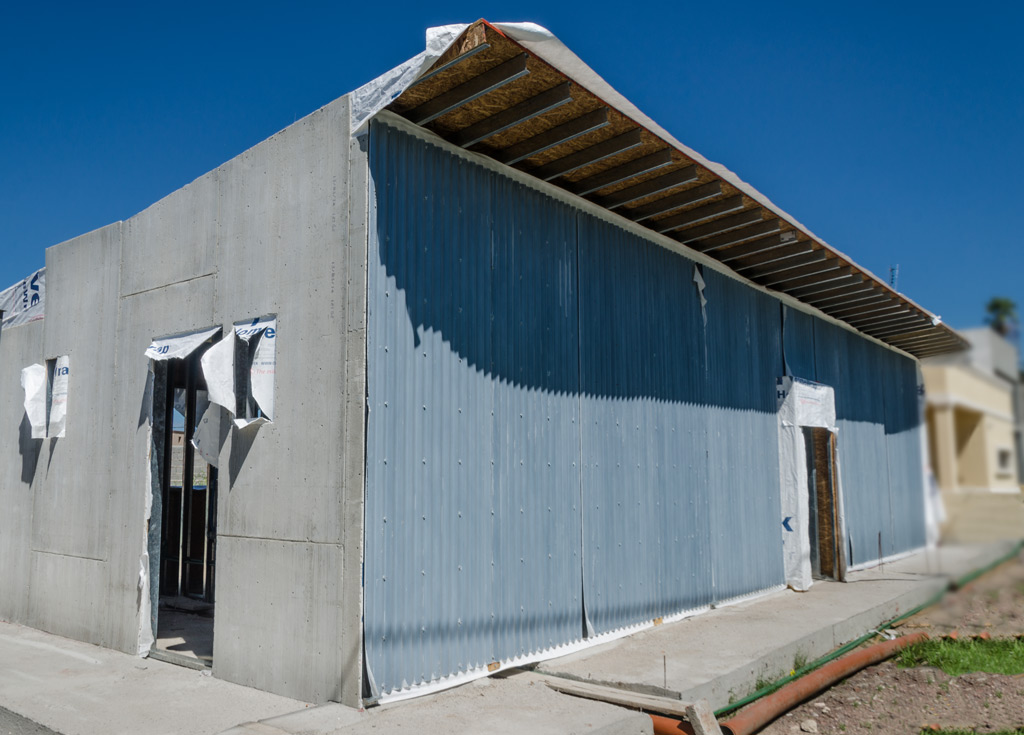 Vista del frente de la casa. Para este proyecto, se definiÃ³ el revestimiento exterior con chapa acanalada prepintada de color negro, y el resto de los muros exteriores se revistieron con placa cementicia.